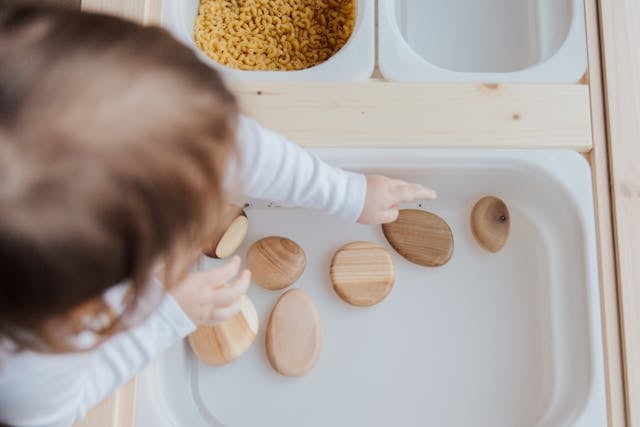 Child Engaging with Wooden Shapes